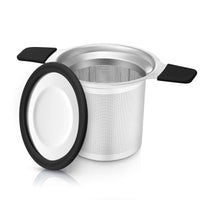 Stainless steel tea infuser with black handles on a white background