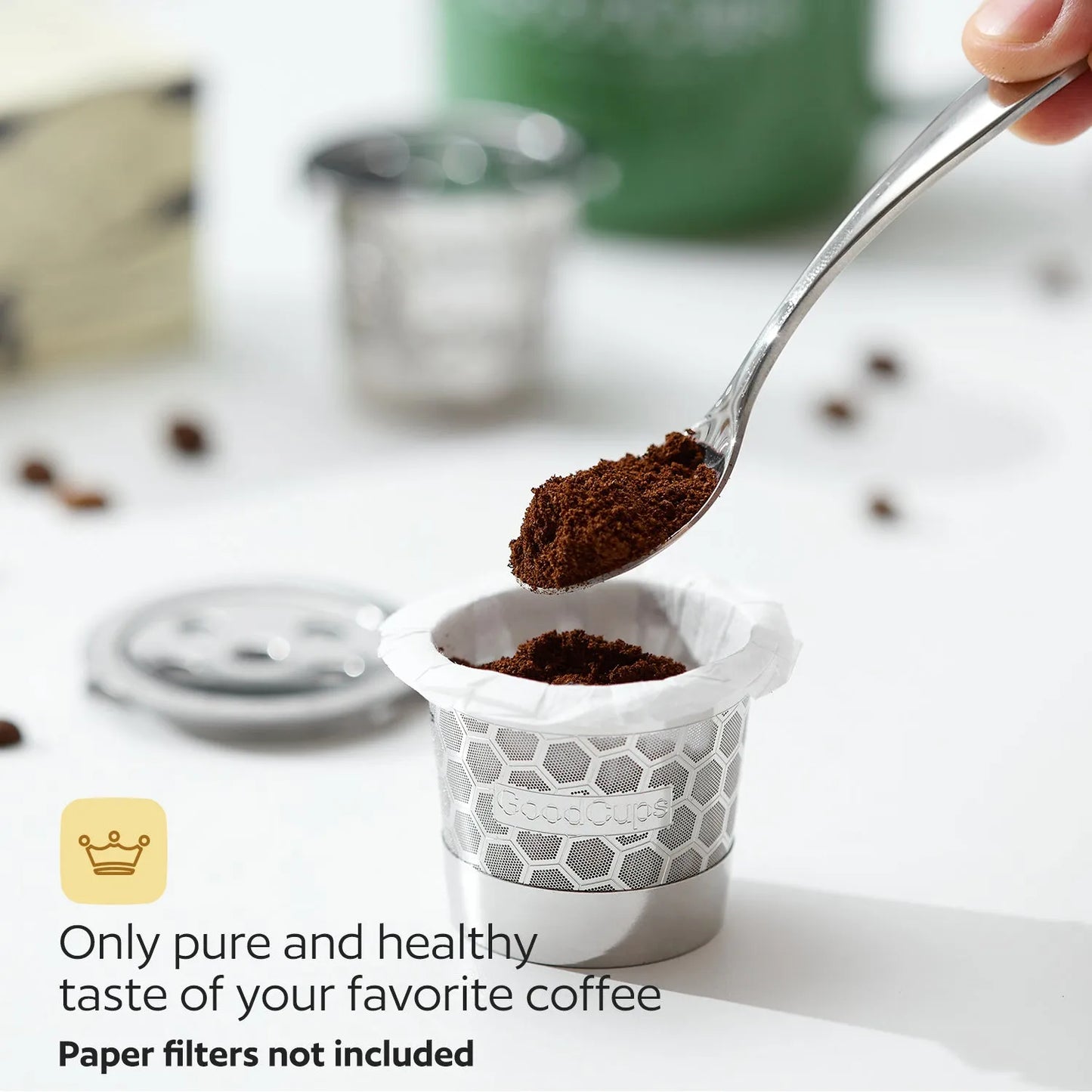 Spoon adding coffee grounds to a stainless steel reusable K-Cup with text about pure and healthy coffee.