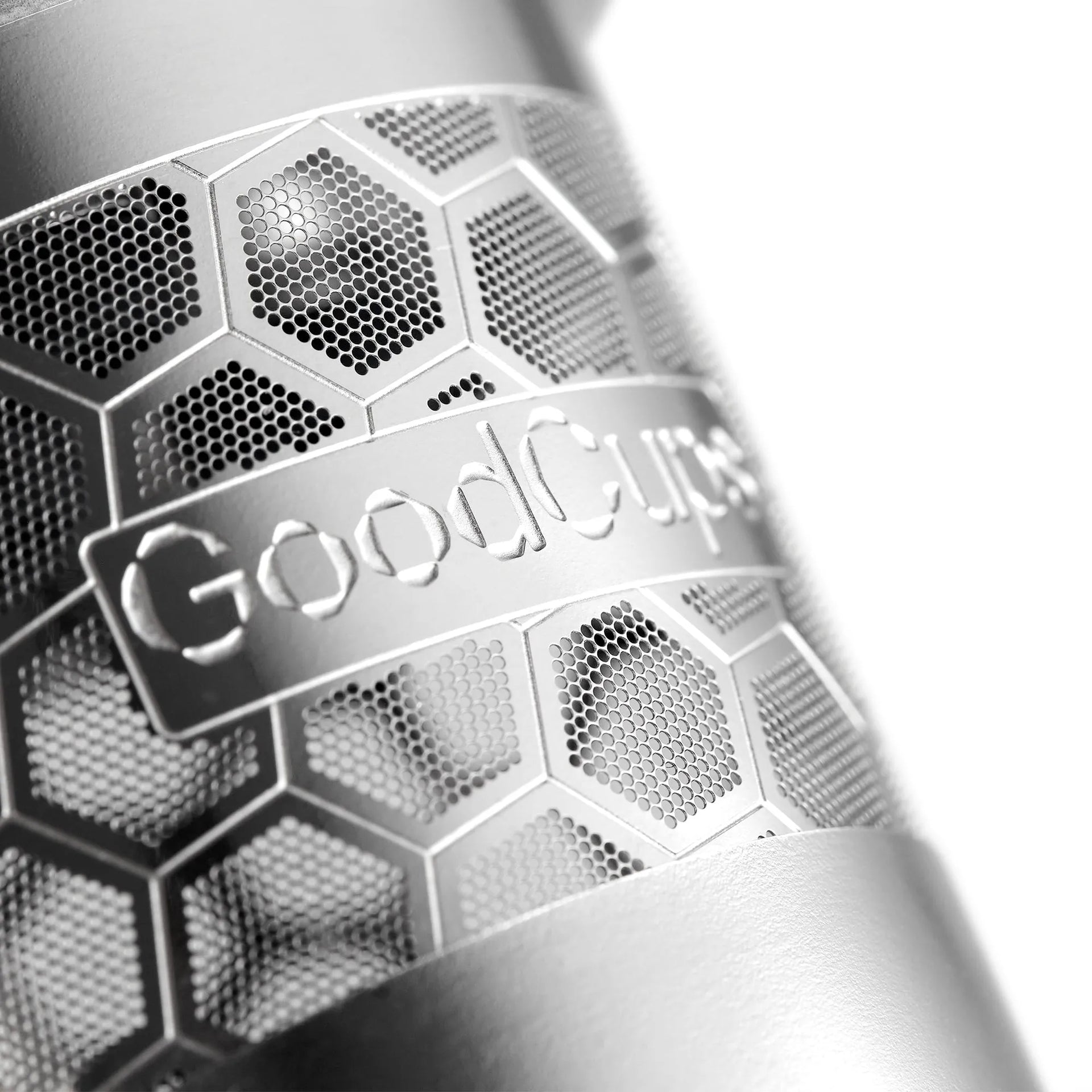 Close-up of a steel reusable K-Cup with 'GoodCups' branding and honeycomb pattern.