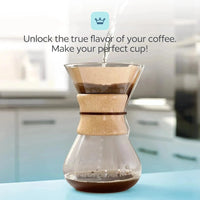 Glass coffee maker with wooden collar on a kitchen counter, with text 'Unlock the true flavor of your coffee. Make your perfect cup!'.
