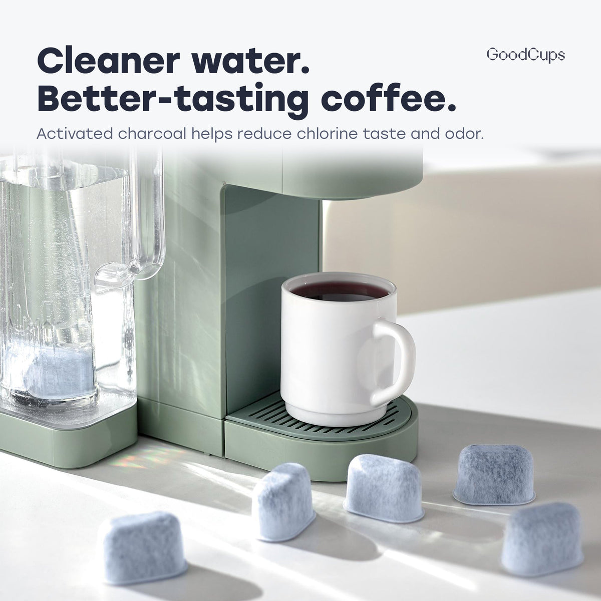 Keurig brewer with a cup of coffee and GoodCups charcoal water filters on the counter