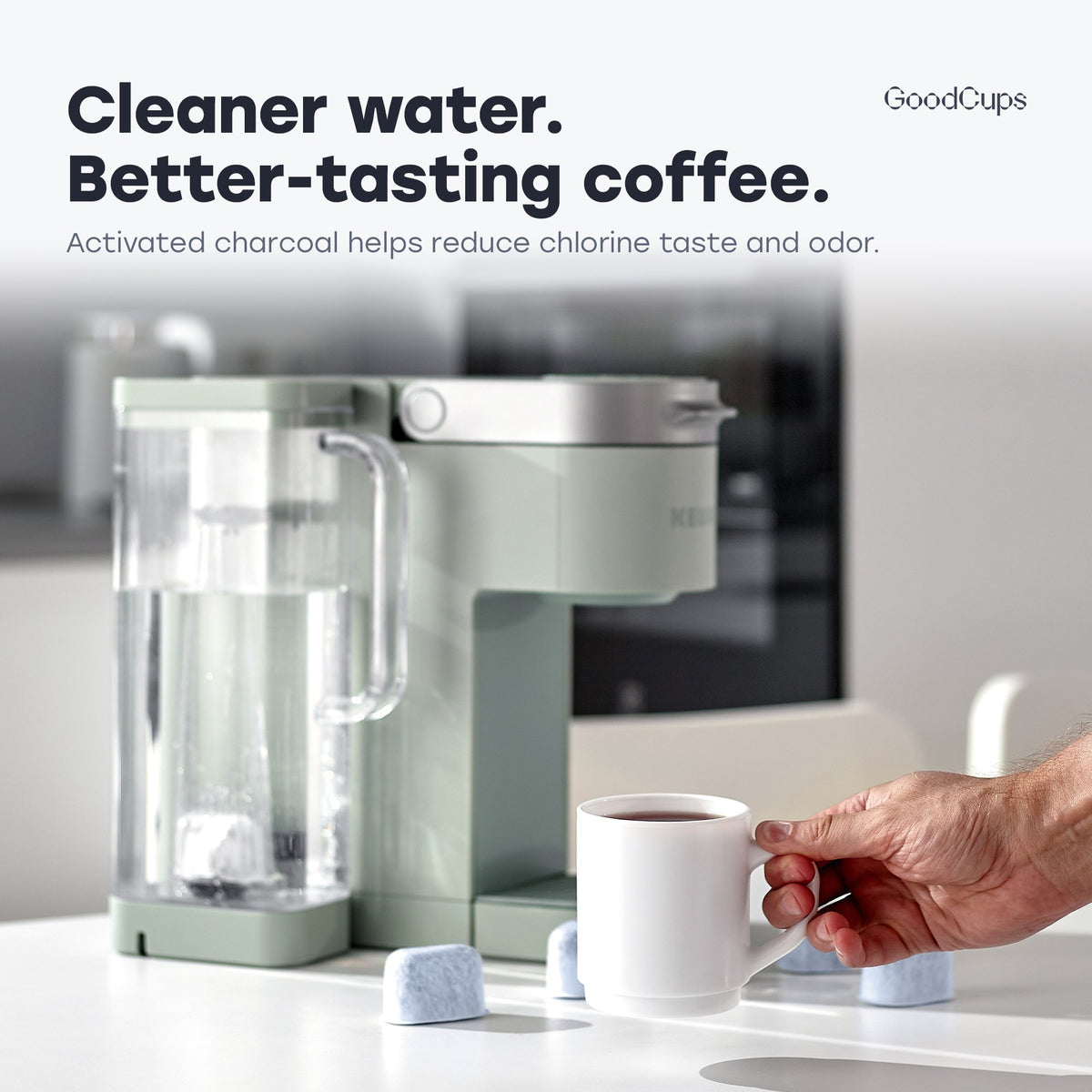 Keurig brewer with the tall water filter holder in its side reservoir and a cup of coffee
