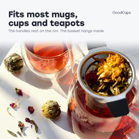 Tea infuser with black handles resting in a glass teapot: fits most mugs, cups and teapots