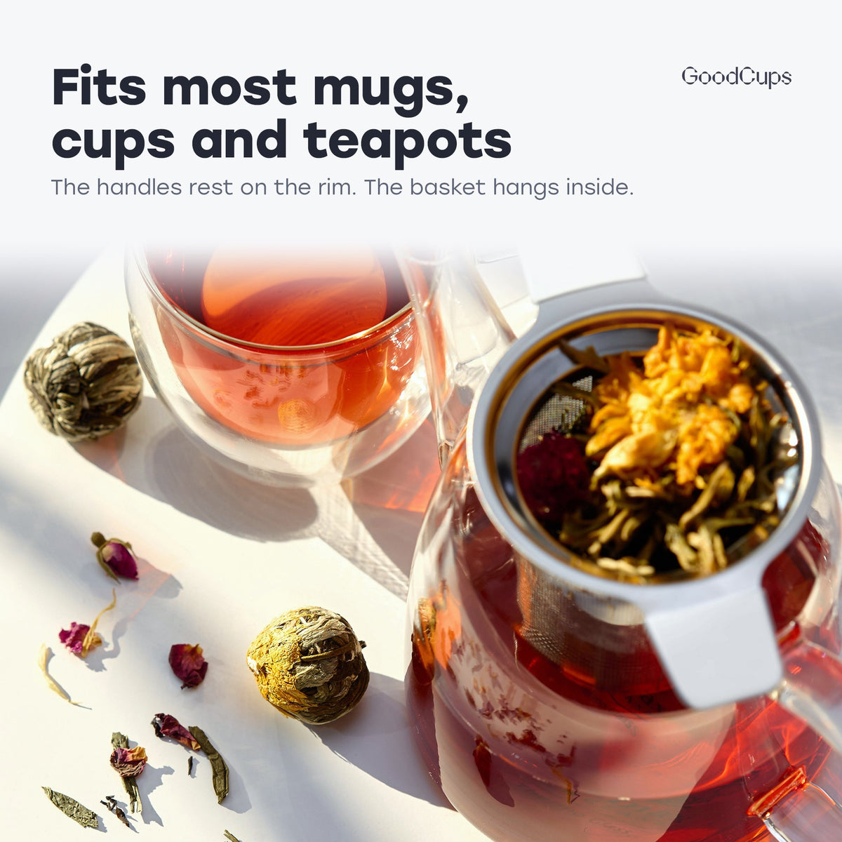 Tea infuser with white handles resting in a glass teapot: fits most mugs, cups and teapots
