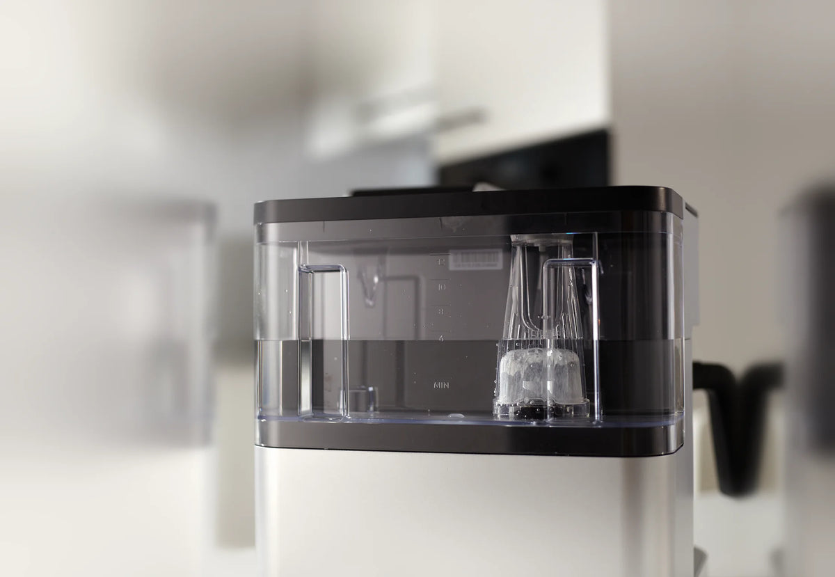 GoodCups charcoal water filter in its holder inside the water reservoir of a coffee maker